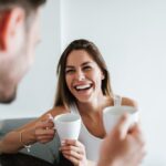 Couple laughing and drinking coffee