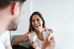 Couple laughing and drinking coffee